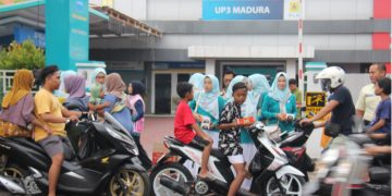 Anggota Srikandi dan PIKK PLN UP3 Madura membagikan takjil gratis kepada pengendara di depan Kantor PLN UP3 Madura, Pamekasan, Jumat (14/3/2025).