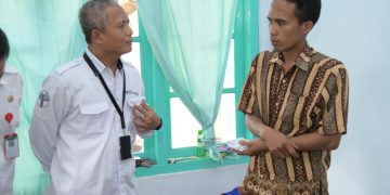 Direktur Utama BPRS Bhakti Sumekar, Hairil Fajar saat menyerahkan bantuan sosial kepada korban musibah ledakan tabung gas balon mainan di Kalianget. (Istimewa)